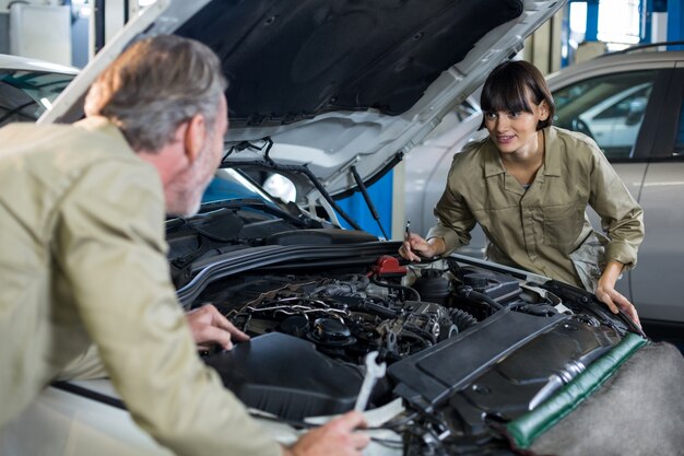 Mechanics examining car engine