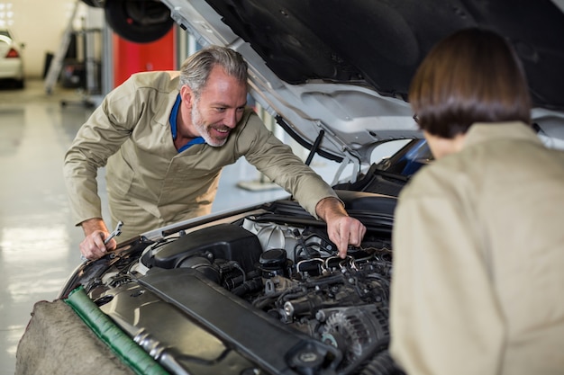 Mechanics examining car engine