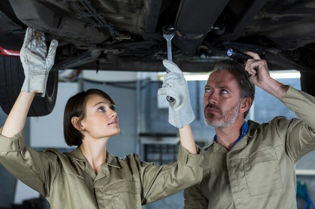 Mechanics examining a car