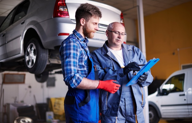 Mechanics repairing a car in the workshop