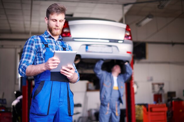 Mechanics repairing a car in the workshop