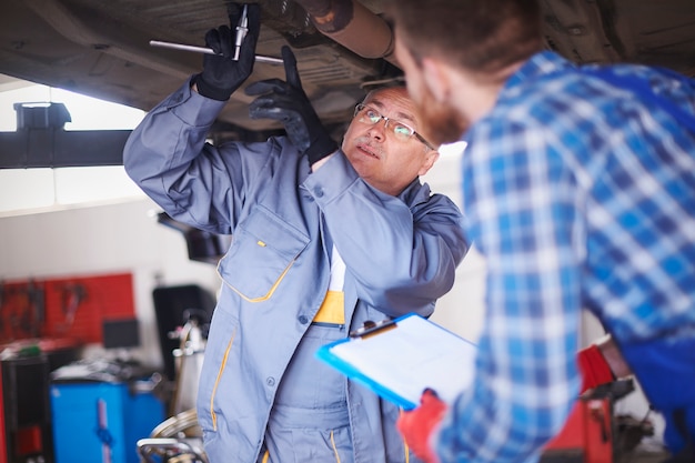 Free photo mechanics repairing a car in the workshop