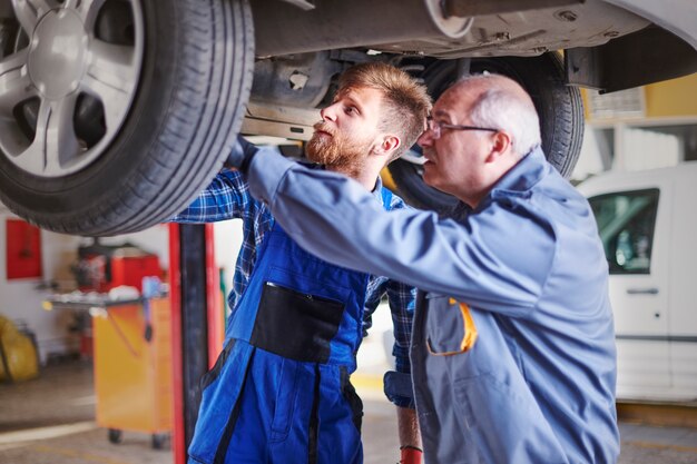 Mechanics repairing a car in the workshop