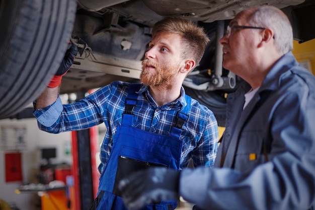 Free photo mechanics repairing a car in the workshop