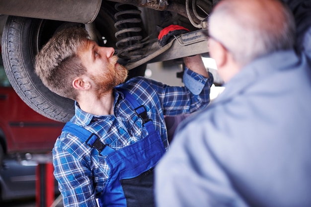 Meccanici che riparano un'auto in officina