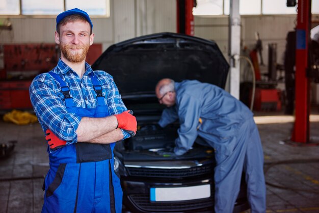 Mechanics repairing a car in workshop