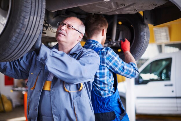 Mechanics repairing a car in the workshop