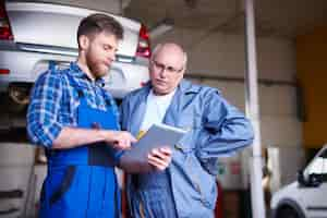 Foto gratuita meccanici che riparano un'auto in officina