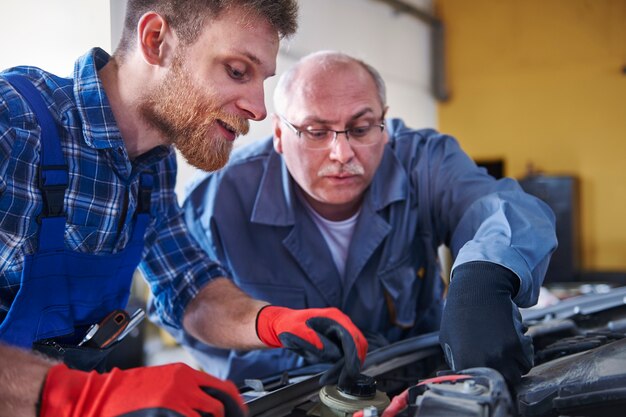 Mechanics repairing a car in the workshop