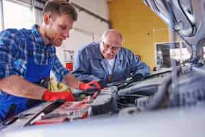 Foto gratuita meccanici che riparano un'auto in officina