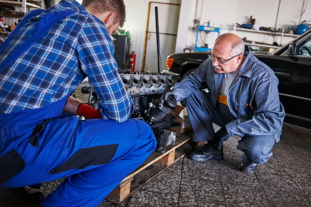 Foto gratuita meccanici che riparano un'auto in officina