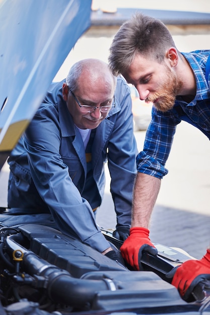 Foto gratuita meccanici che riparano un'auto in officina