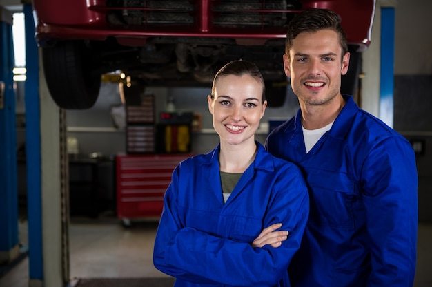 Mechanics standing under a car