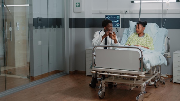 Medic holding bottle of pills to give to sick patient in bed. Man working as doctor giving flask with healthcare treatment to young woman, prescription medicine in jar to cure disease