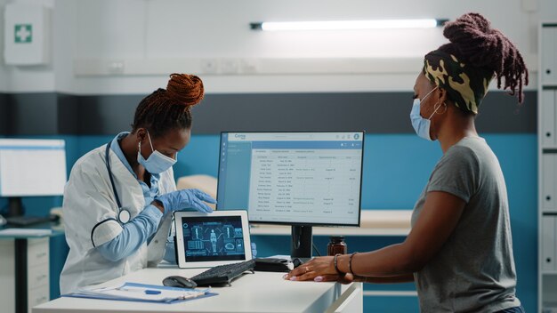 Medic and patient looking at human body analysis