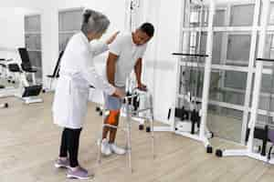 Free photo medical assistant helping patient with physiotherapy exercises