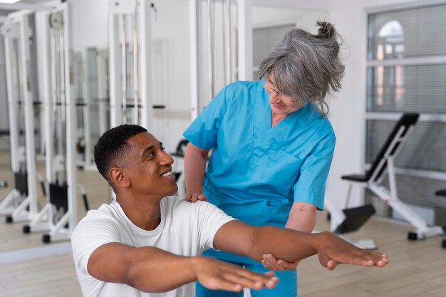 Medical assistant helping patient with physiotherapy exercises