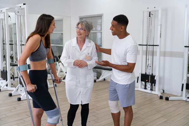 Medical assistant helping patients with physiotherapy exercises