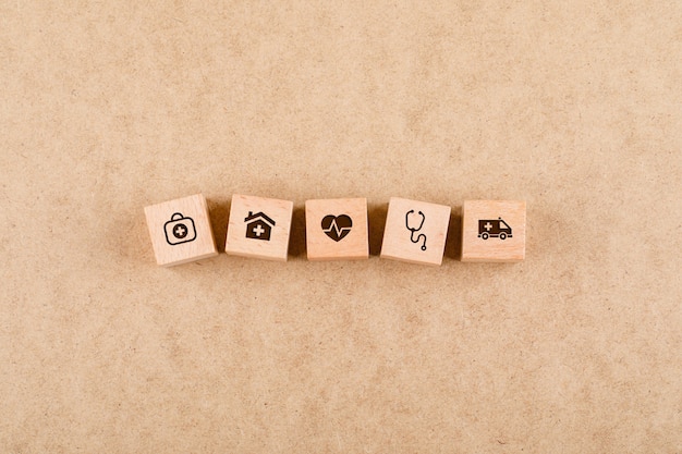 Free photo medical check up concept with wooden blocks with medical icons  flat lay.