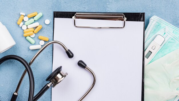 Medical desk composition with empty clipboard