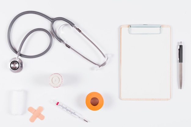 Medical equipments with clipboard and pen on white background