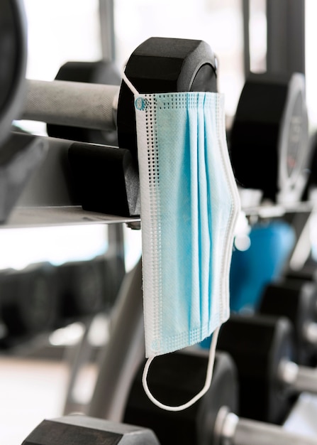 Medical mask in the gym hanging from weights