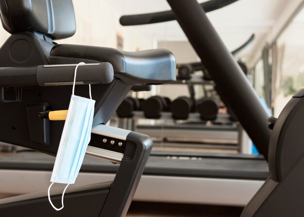 Medical mask hanging from treadmill at the gym