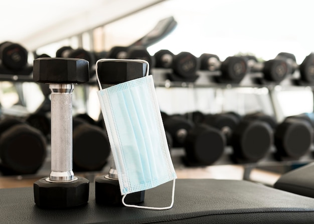 Medical mask hanging from weights in the gym