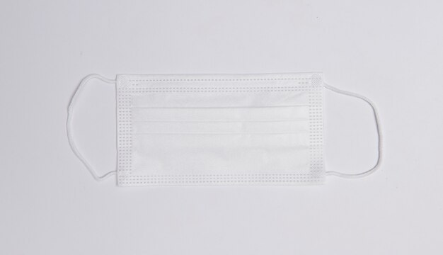 Medical mask on white  surface flat lay top view with copy space. Protection against virus, coronavirus, flu, colds, diseases. Traditional medical tool, concept of health. medical background