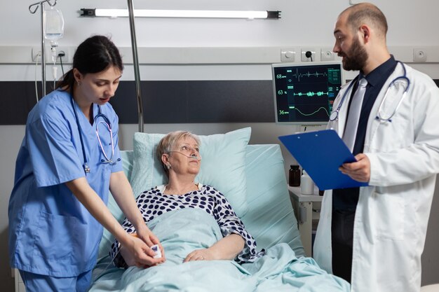 年配の女性患者に酸素濃度計を取り付ける医療看護師