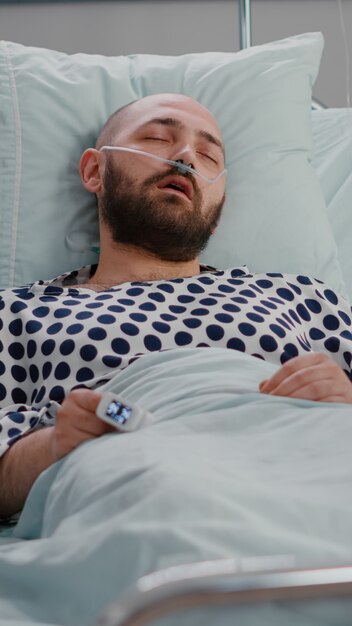 Medical nurse checking temperature monitoring sickness symptom during recovery appointment in hospit...