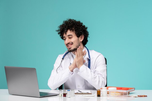 Medical serious cute handsome doctor working on computer in lab coat clapping hands