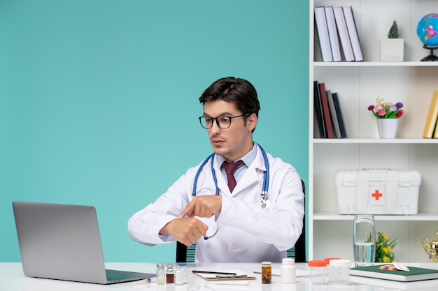 Medical serious cute smart doctor in lab coat working remotely on computer showing at clocks