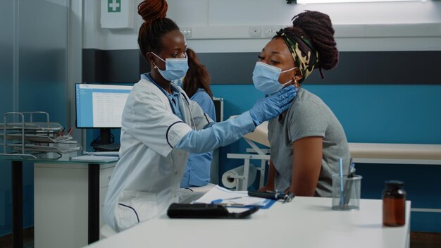 연례 검진 방문에서 안면 마스크를 착용하면서 질병을 앓고 있는 의료 전문가 상담 환자. 코비드 19 전염병 동안 의료를 위해 의사로부터 상담을 받는 젊은 사람.