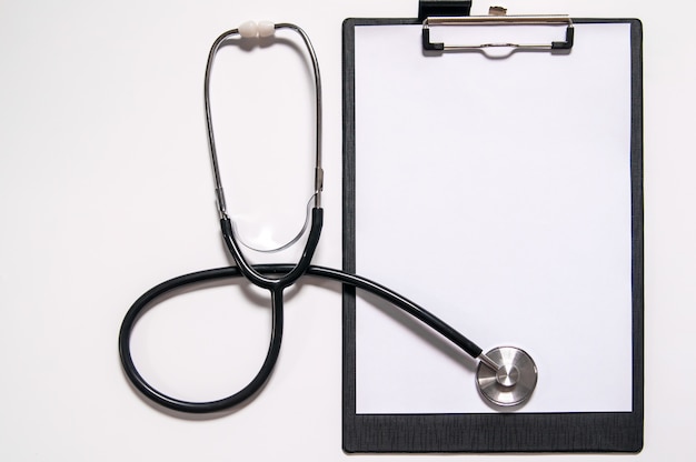 Medical stethoscope or phonendoscope isolated on white background cut out. Stethoscope and clipboard with blank white sheet of paper and copy space. Medical concept