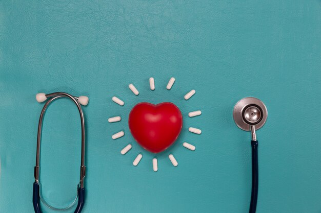 Medical stethoscope and pills on blue 