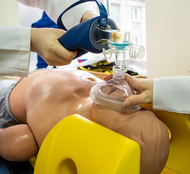 Foto gratuita studenti di medicina che praticano la rianimazione cardiopolmonare di emergenza su una bambola di pratica medica