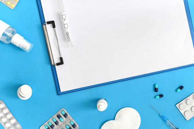 Medical supplies, notepad and covid test composition on blue background. Top view