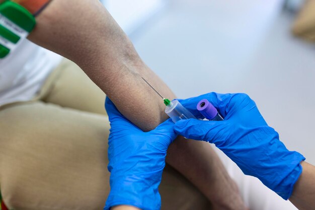 患者から血液サンプルを採取する滅菌ゴム手袋を使用して、患者ラボアシスタントの採血サービスを行う医療技術者