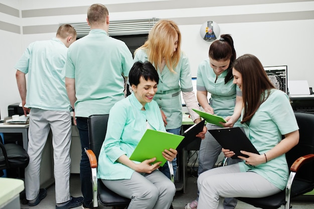 Medical themeObservation room with a computer tomograph The group of female doctors with clipboards meeting in the mri office at diagnostic center in hospital