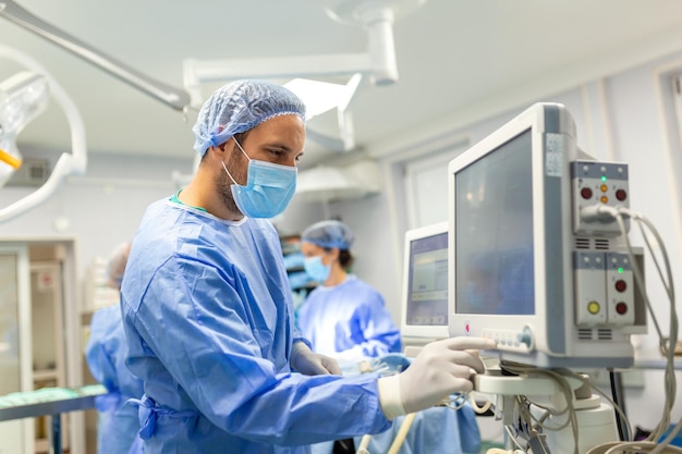 Medical ventilator being monitored by anaesthetist surgeon using monitor in operating room