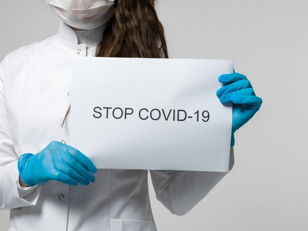 Medical worker holding stop covid-19 leaflet