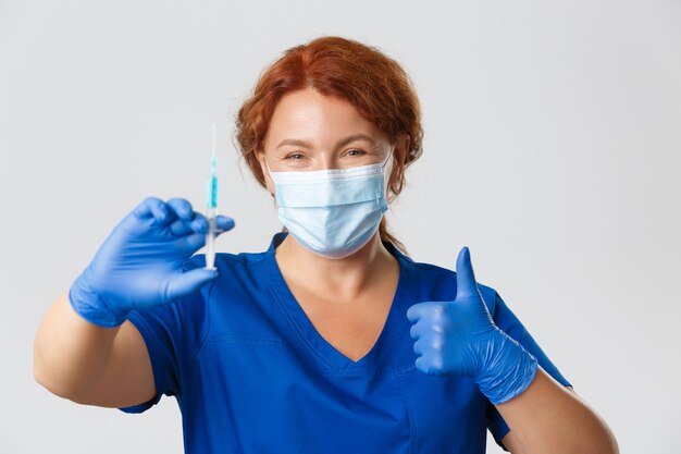 Медицинские работники концепция пандемии коронавируса covid улыбается женщина-врач врач в маске для лица ...