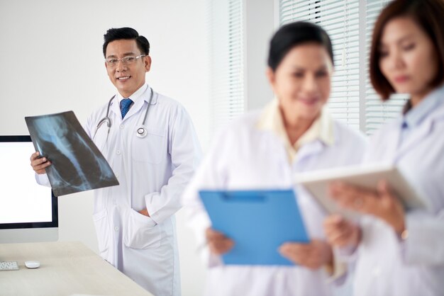 Medical workers having a concilium, male doctor with Xray in focus