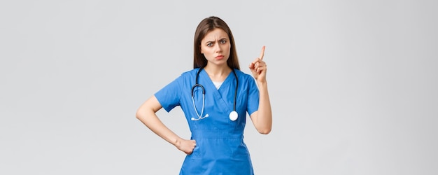 Medical workers healthcare covid and vaccination concept frowning young female nurse or doctor in bl