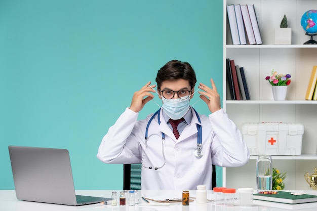 Медицинская работа на компьютере удаленно серьезный милый умный доктор в лабораторном халате в маске