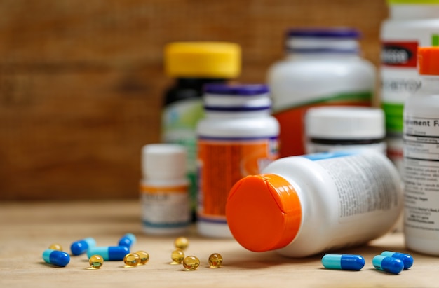 Бутылки и таблетки для медицины на деревянном столе