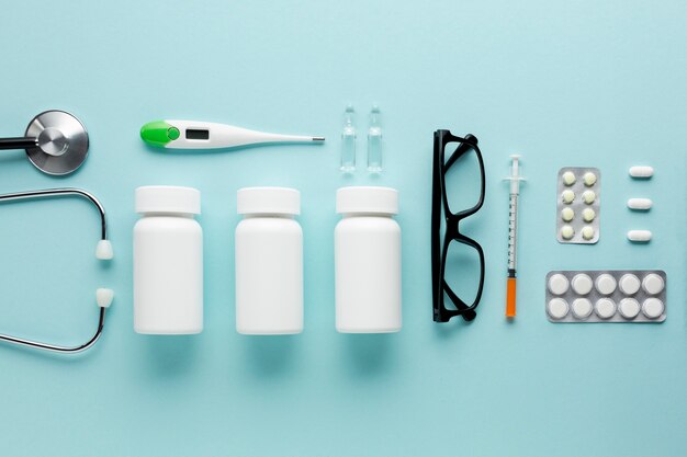 Medicines and healthcare accessories arranged on blue surface