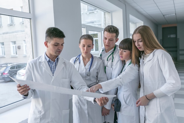 Medics looking at cardiogram in hall