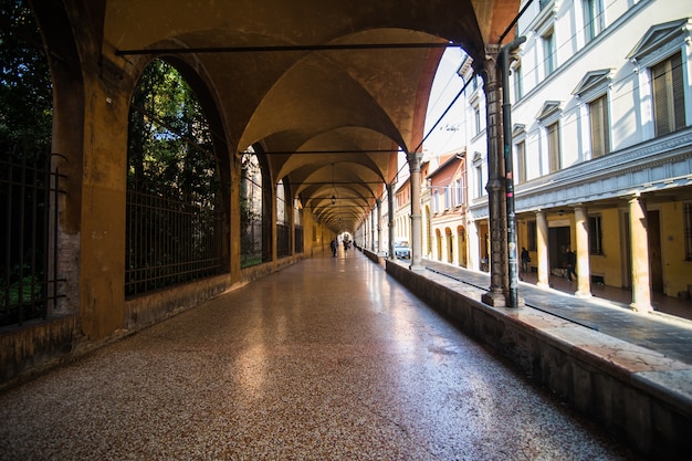 Free photo medieval street portico with bright colored houses in the old town in the sunny day, bologna, emilia-romagna, italy